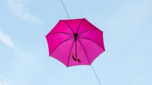 Jakobsweg Moissac rosa Oktober Regenschirm vor blauem Himmel